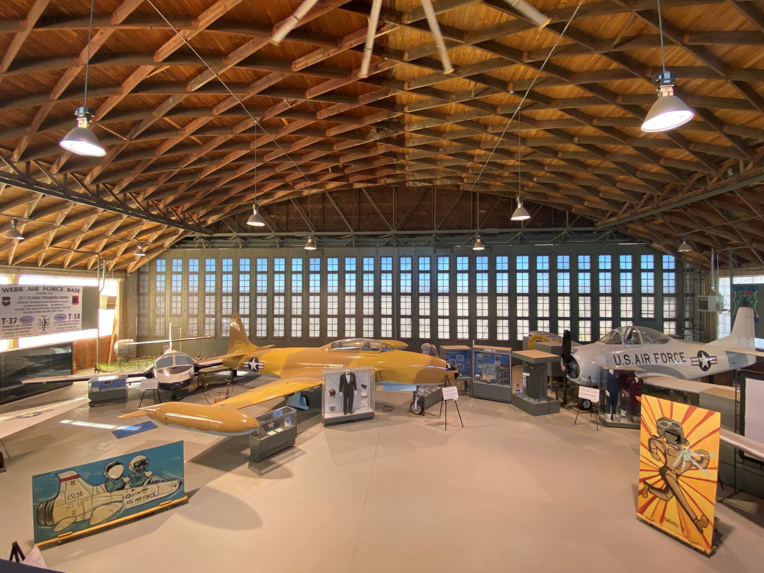 Interior of Hangar 25 displaying vintage aircraft and memorabilia highlighting it's aviation hist