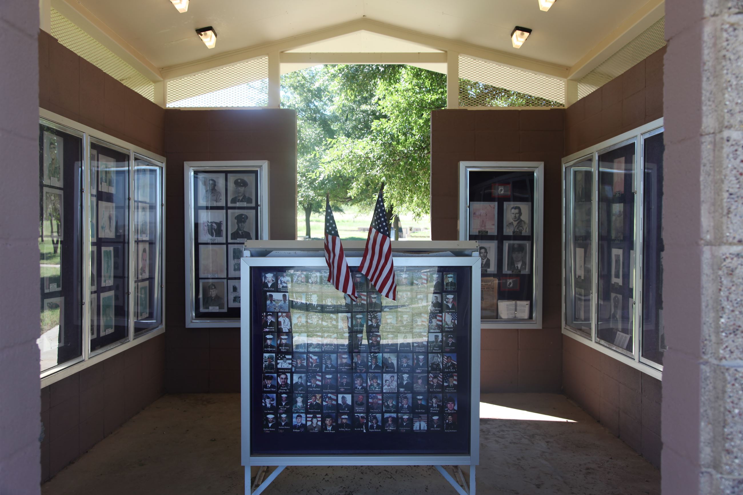 Display cases with veterans' memorabilia at the Big Spring Vietnam Memorial, framed by American f