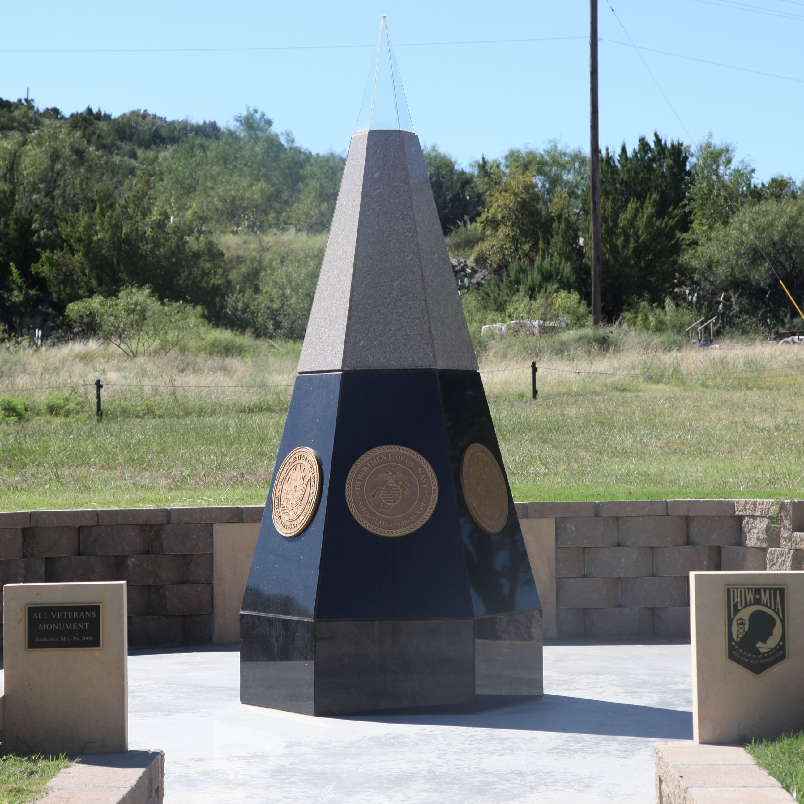 Vietnam Memorial obelisk with service branch emblems at Big Spring, honoring fallen soldiers.